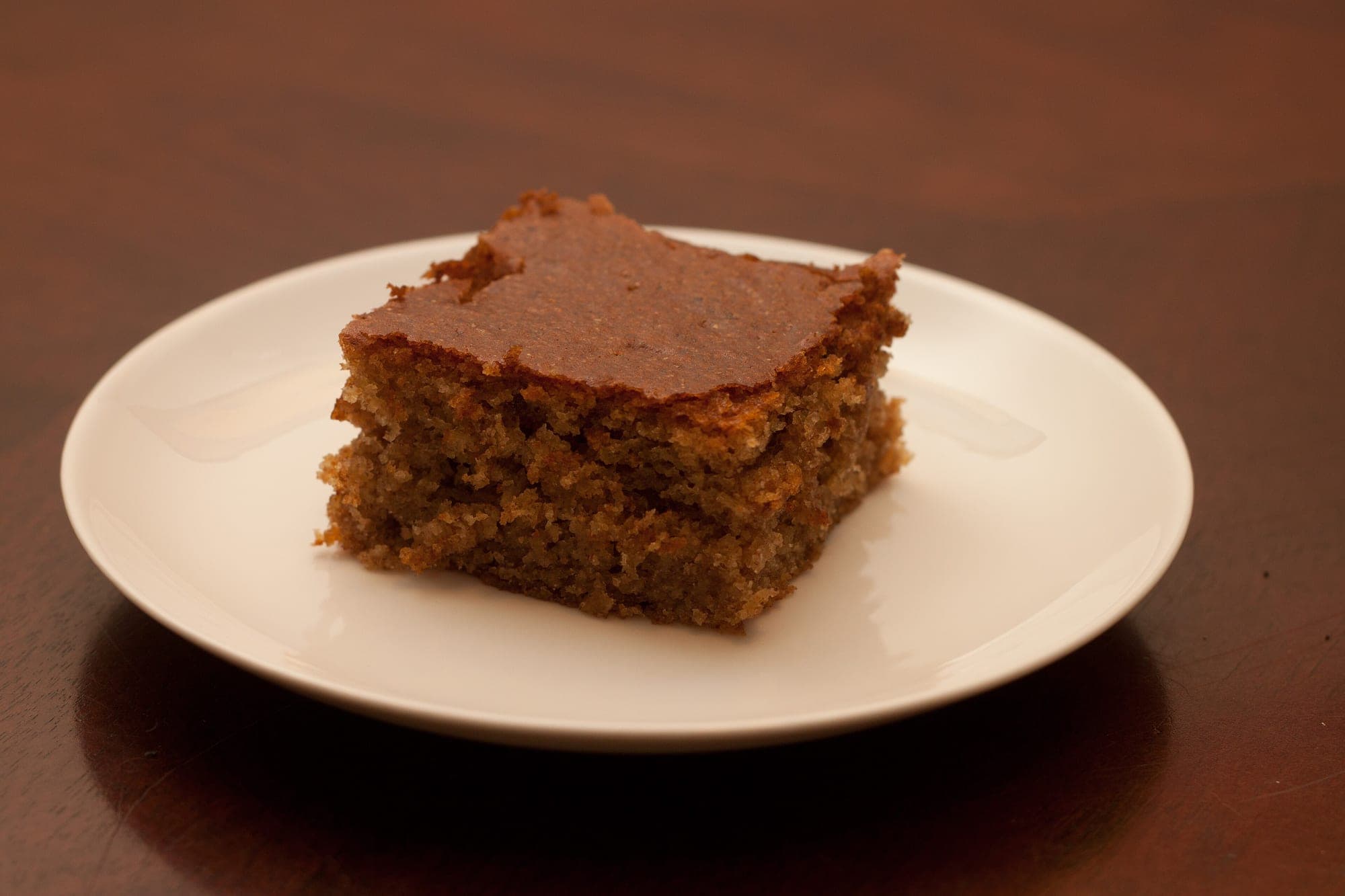 A slice of vanilla yogurt loaf cake with a golden crust on a plate